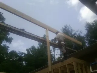 Carpenter setting a ridge beam over a new addition frame — Ice Dam Removal by Roofing Brothers in Cottonton