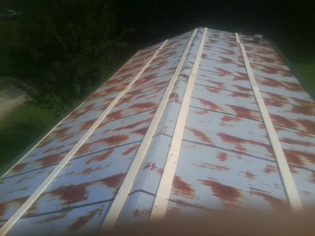 Rusted metal roof panels with new wood purlins before replacement — Storm Damage Roof Repair in Cottonton by Roofing Brothers