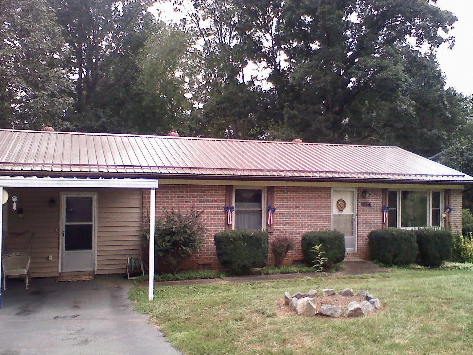 Bronze metal roof and carport on a brick ranch home — Roof Repair work by our crew in Cottonton