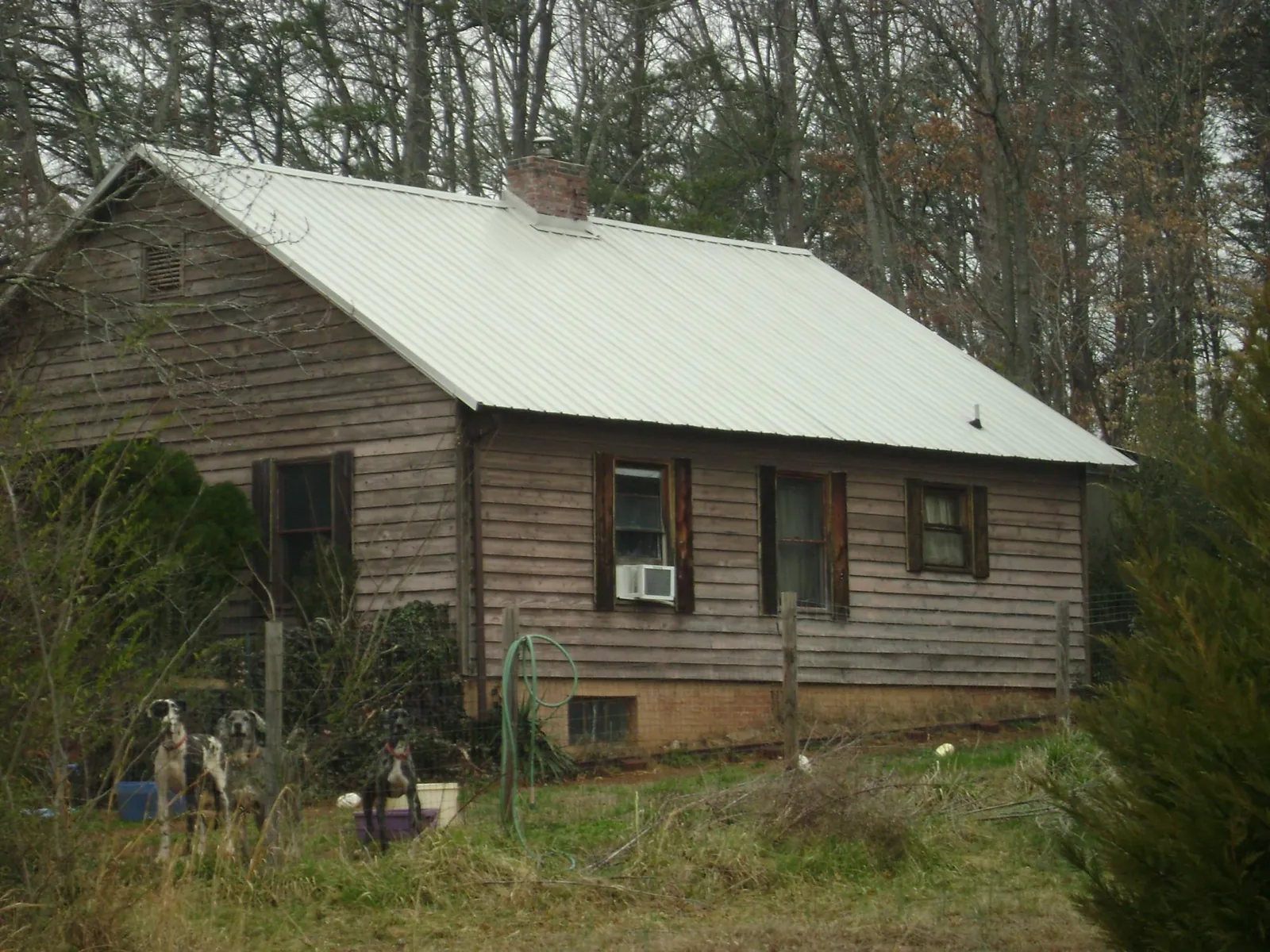 White metal roof on an old wood sided farmhouse, from a Metal Roof Installation job in Cottonton